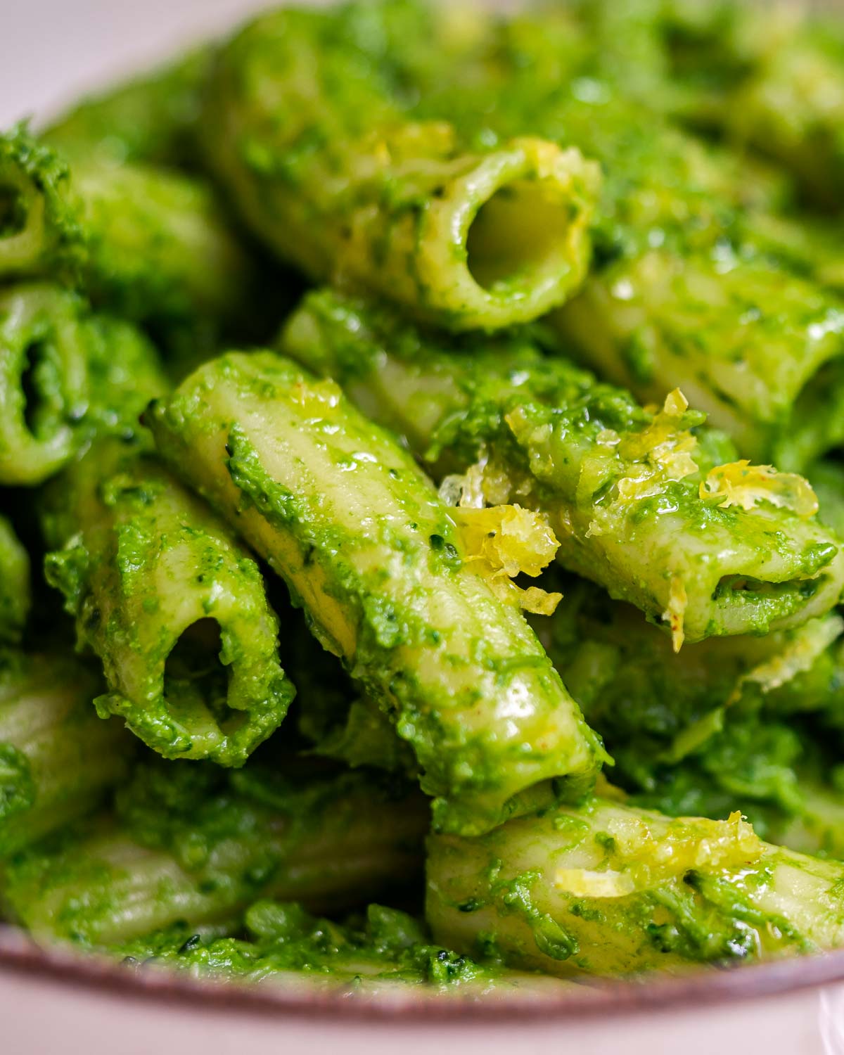 Green pasta served with lemon zest
