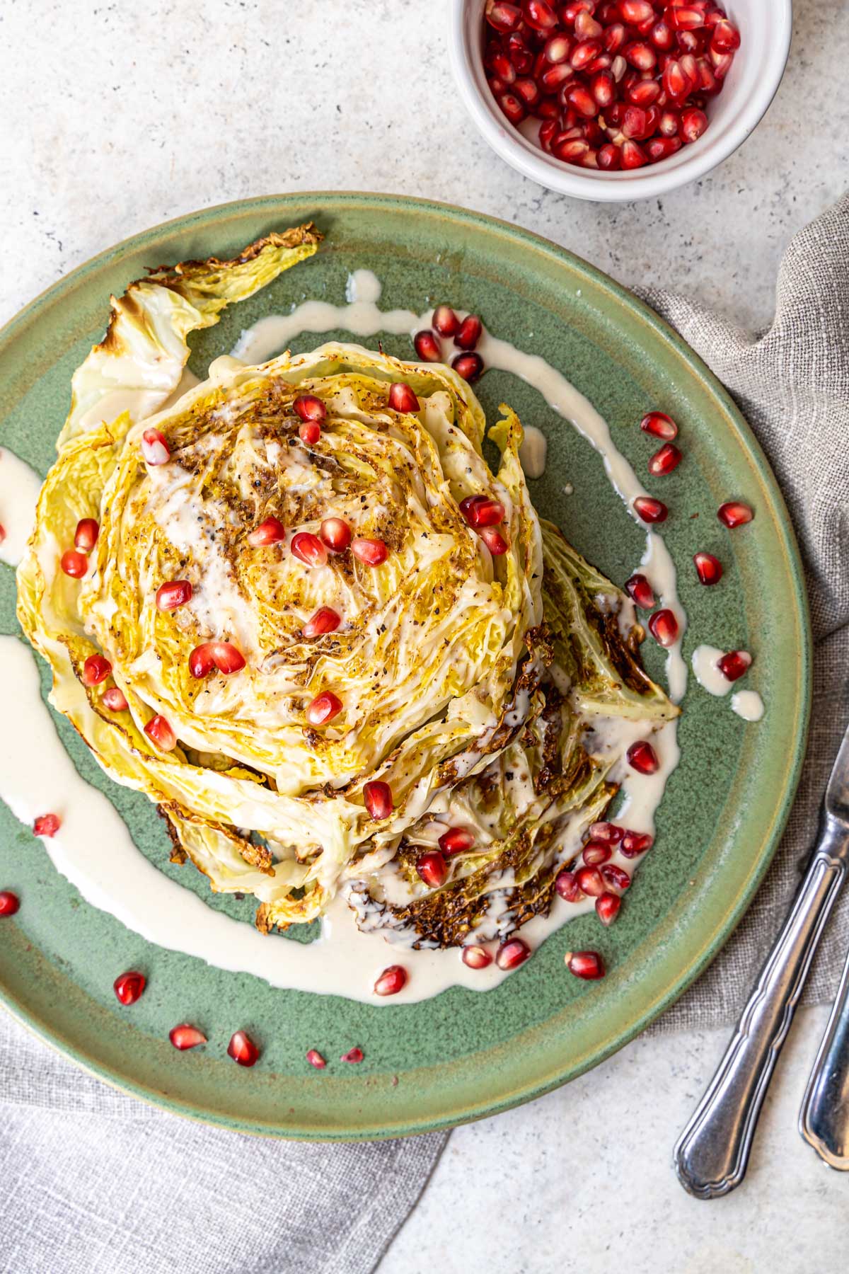 Cabbage Steaks served with Tahini Sauce and Pomegranates