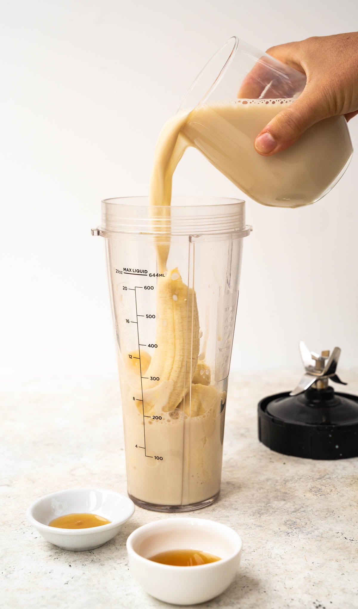 Pouring milk with the rest of the ingredients in ninja blender