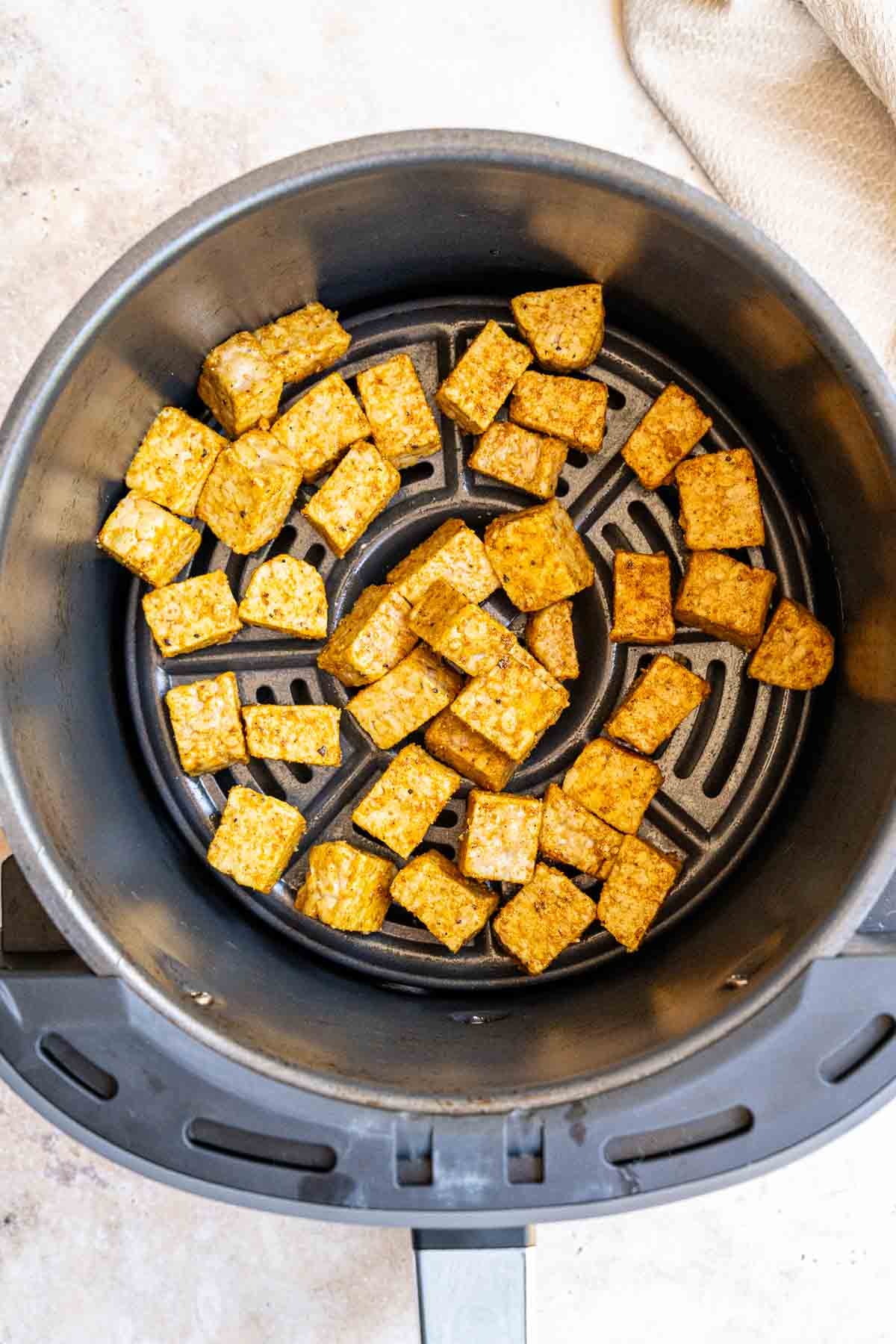Adding marinated tempeh into air fryer basket