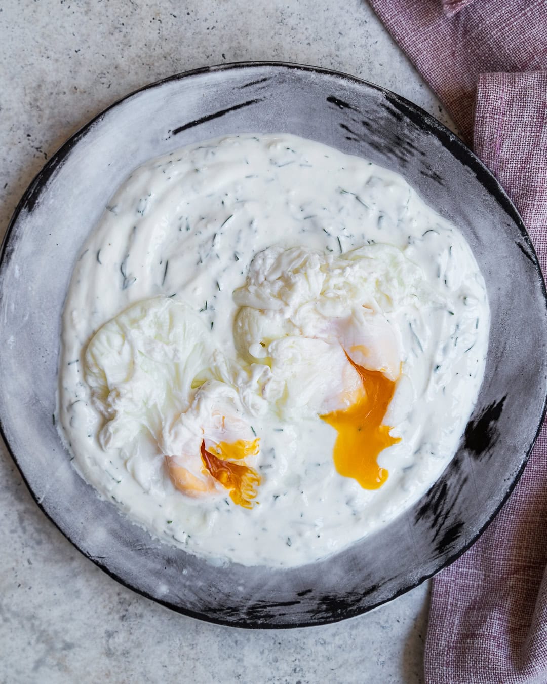 Adding the poached eggs on the yogurt.