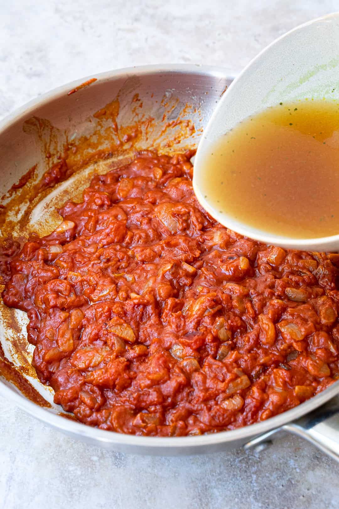 Pouring vegetable stock to the pan