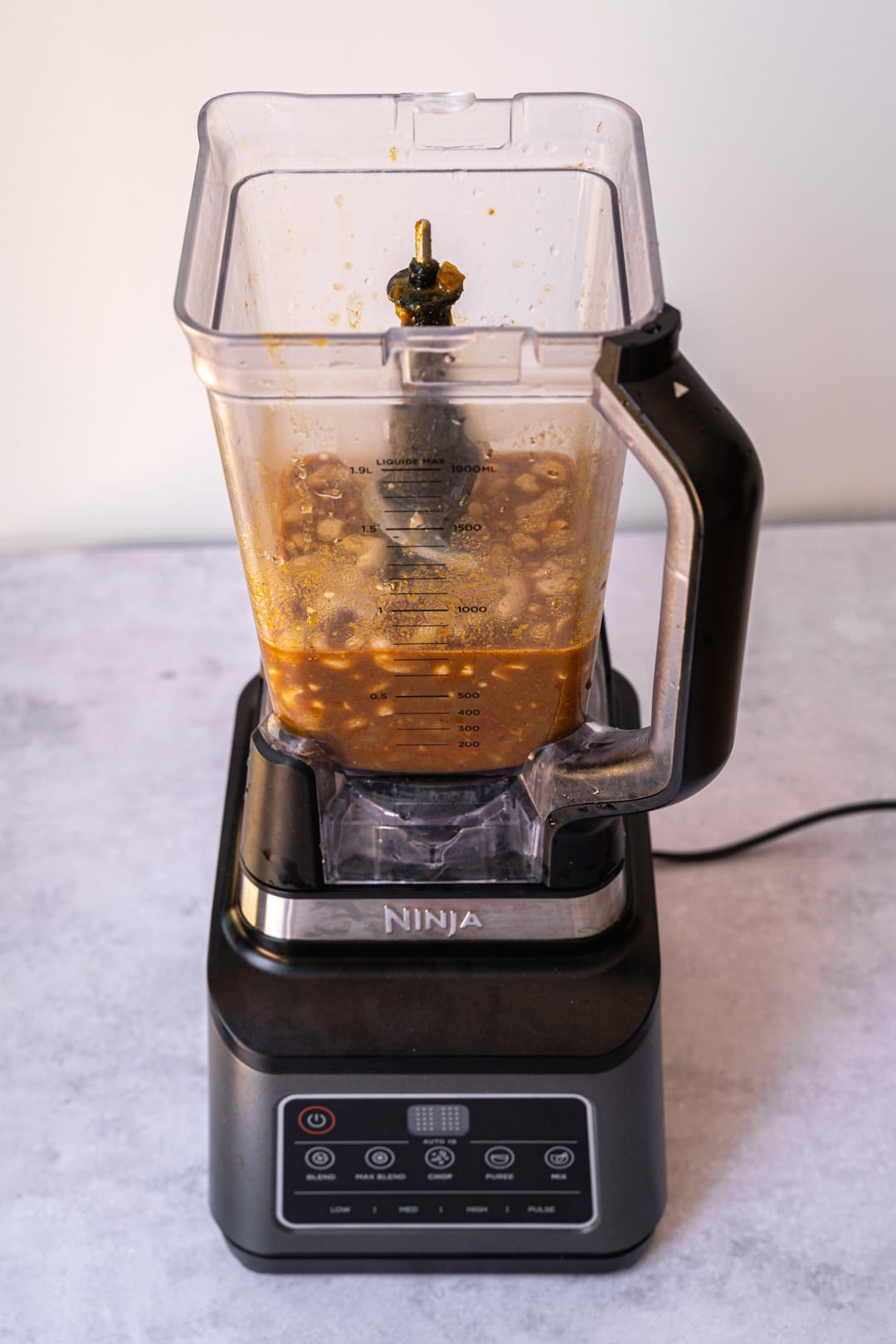 Adding cashews and sauce to the blender to make a smooth sauce.