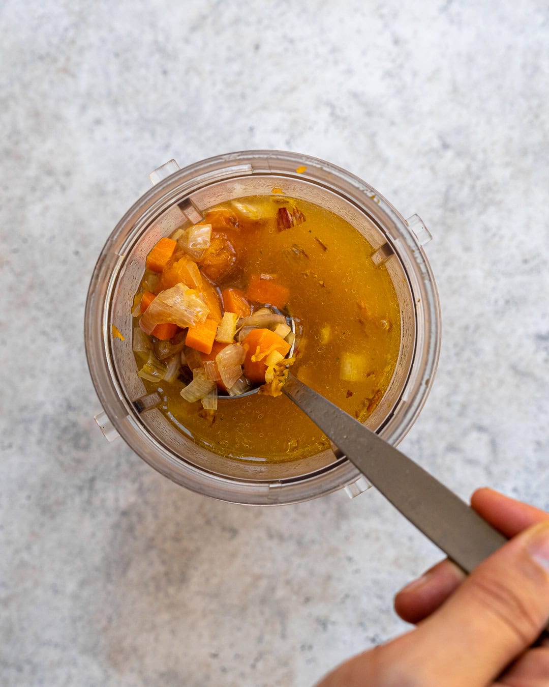 Transferring all the ingredients to a blender jug with vegetable stock.