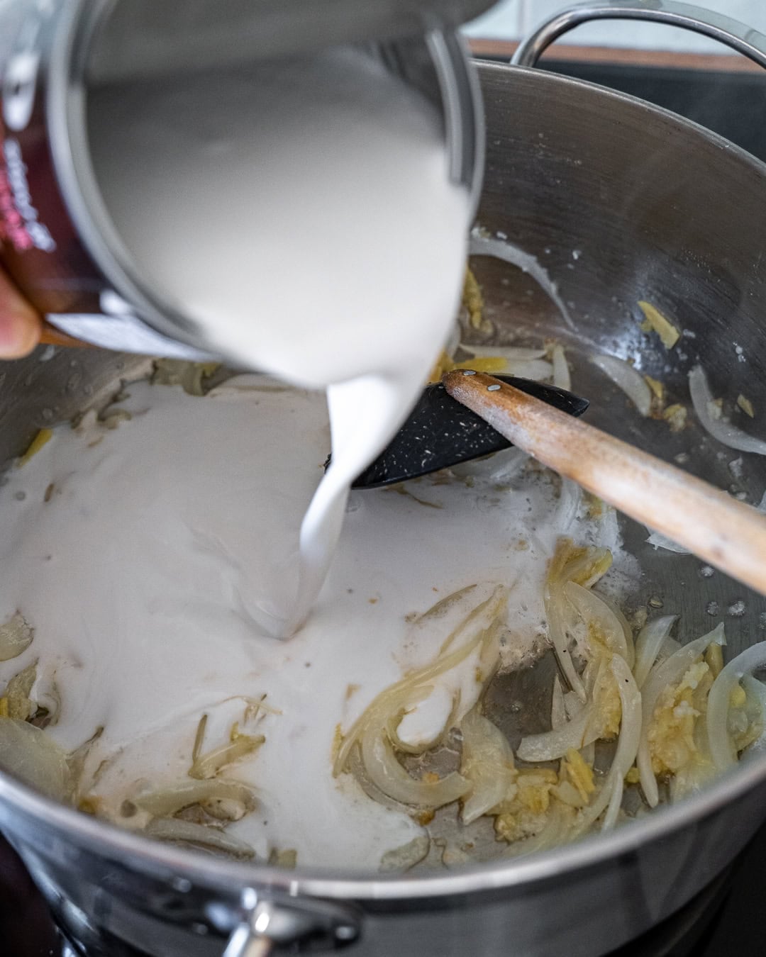 Adding coconut milk to the pan