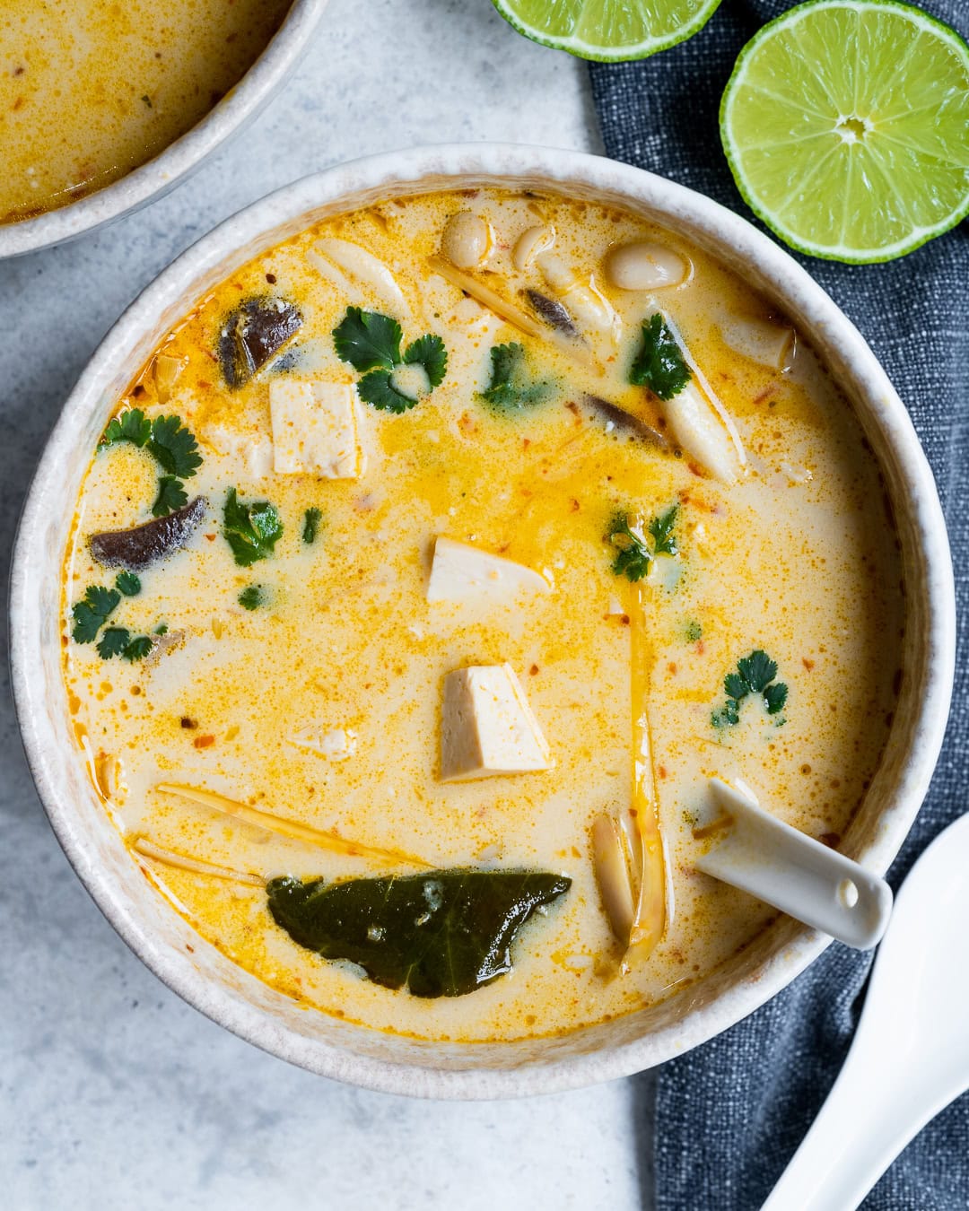 serving Thai soup with lime juice and fresh cilantro