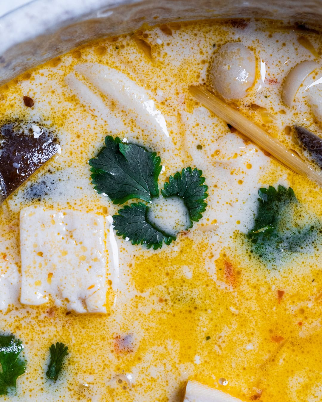 Adding coconut milk to the soup