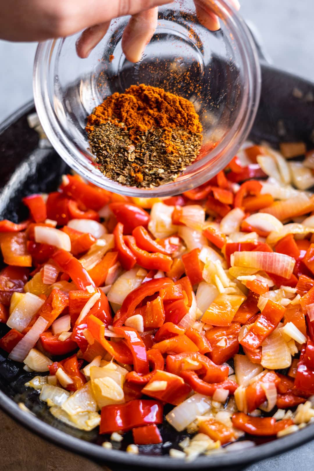 adding spices to the shakshuka pan