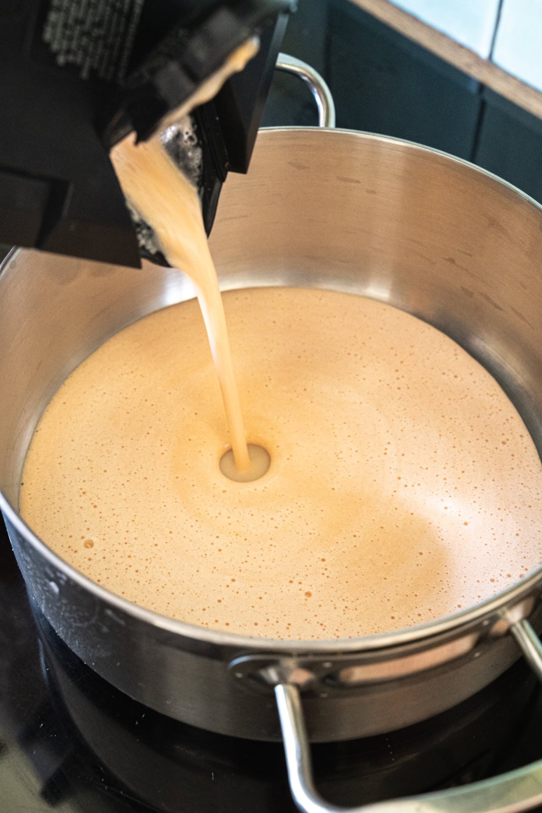 Pouring the red lentil mixture into a pan to heat.