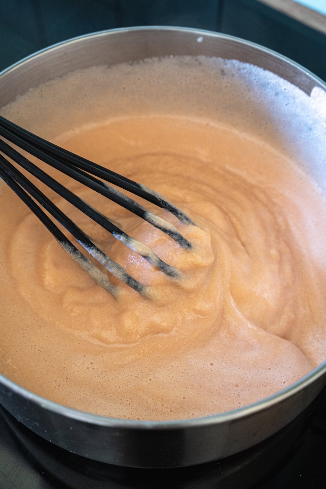stirring the red lentil mixture while thickening.