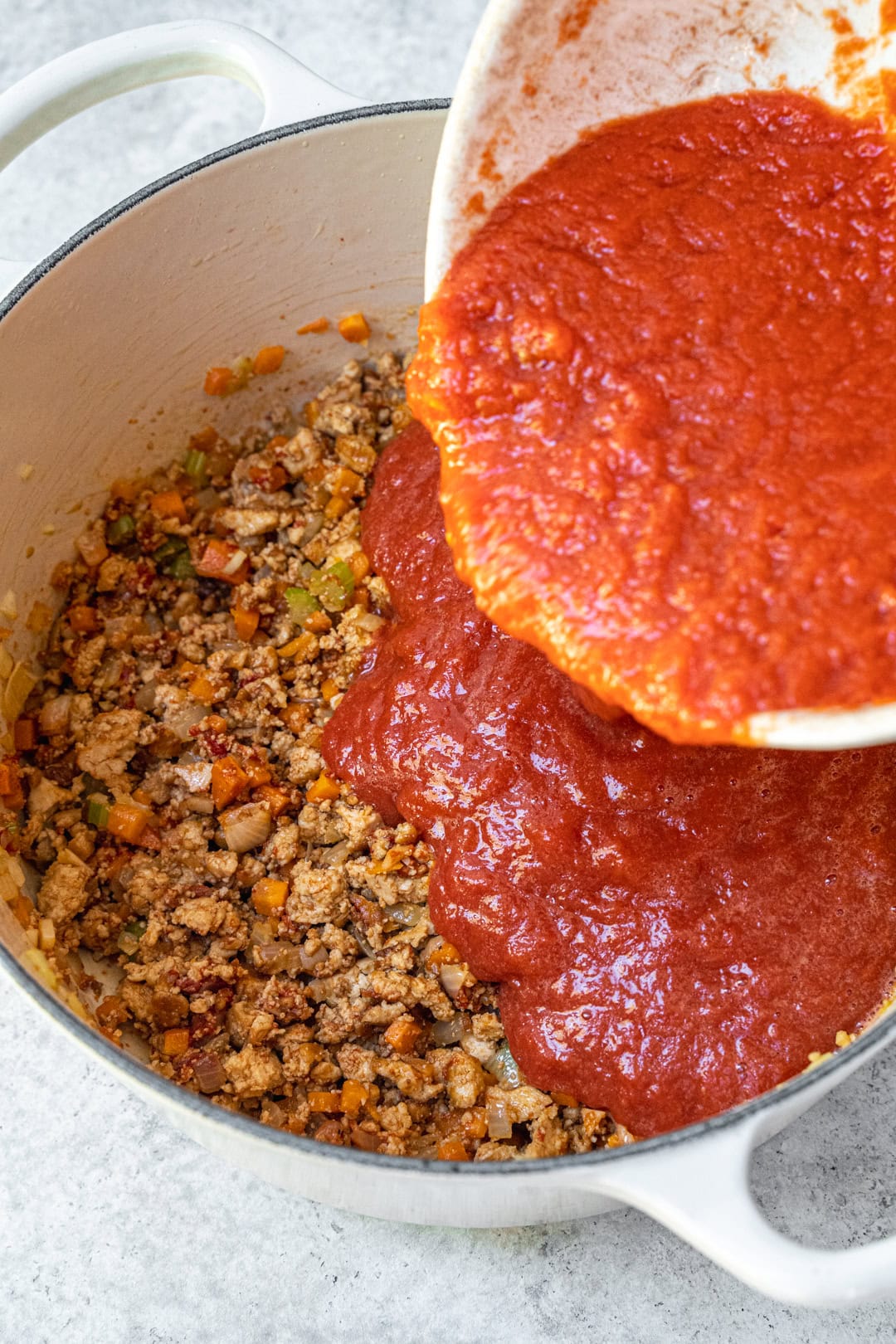 adding tomato passata to the pot