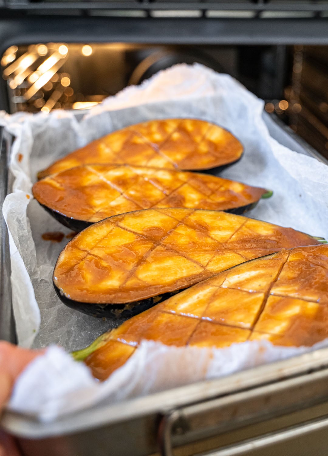Placing the aubergines in the oven to roast.