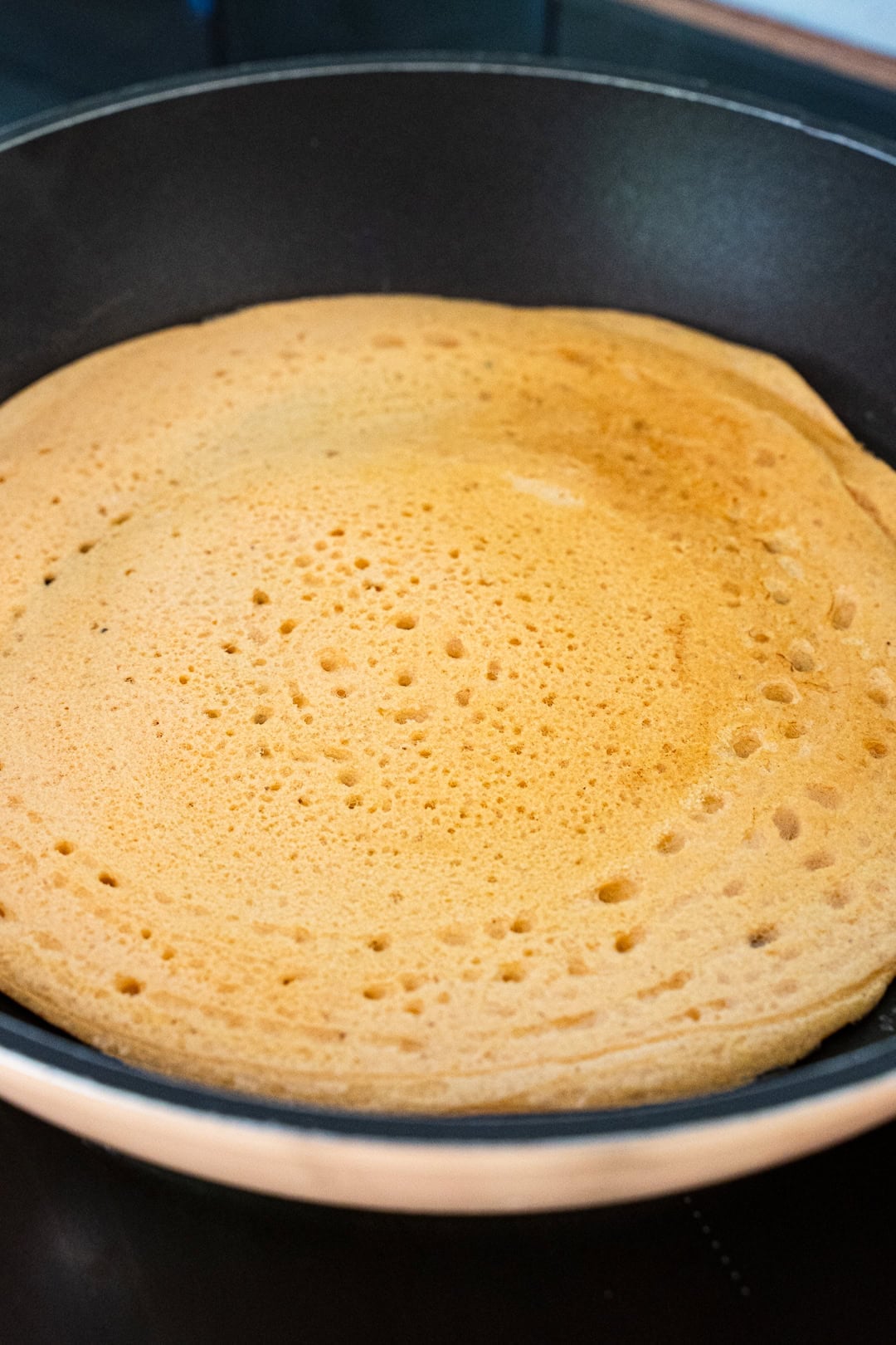 cooking red lentil batter in non-stick pan 
