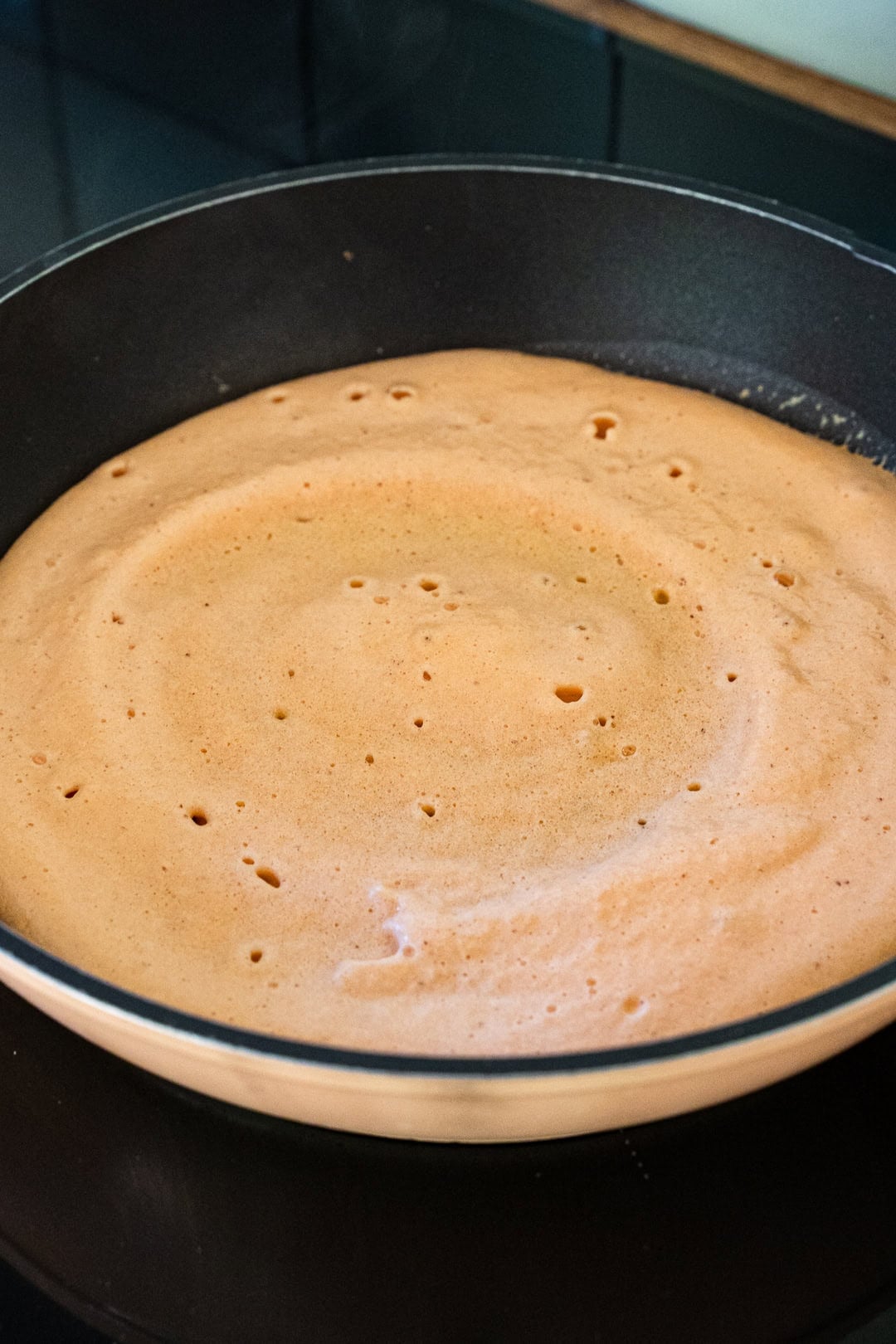 cooking red lentil batter in non-stick pan 