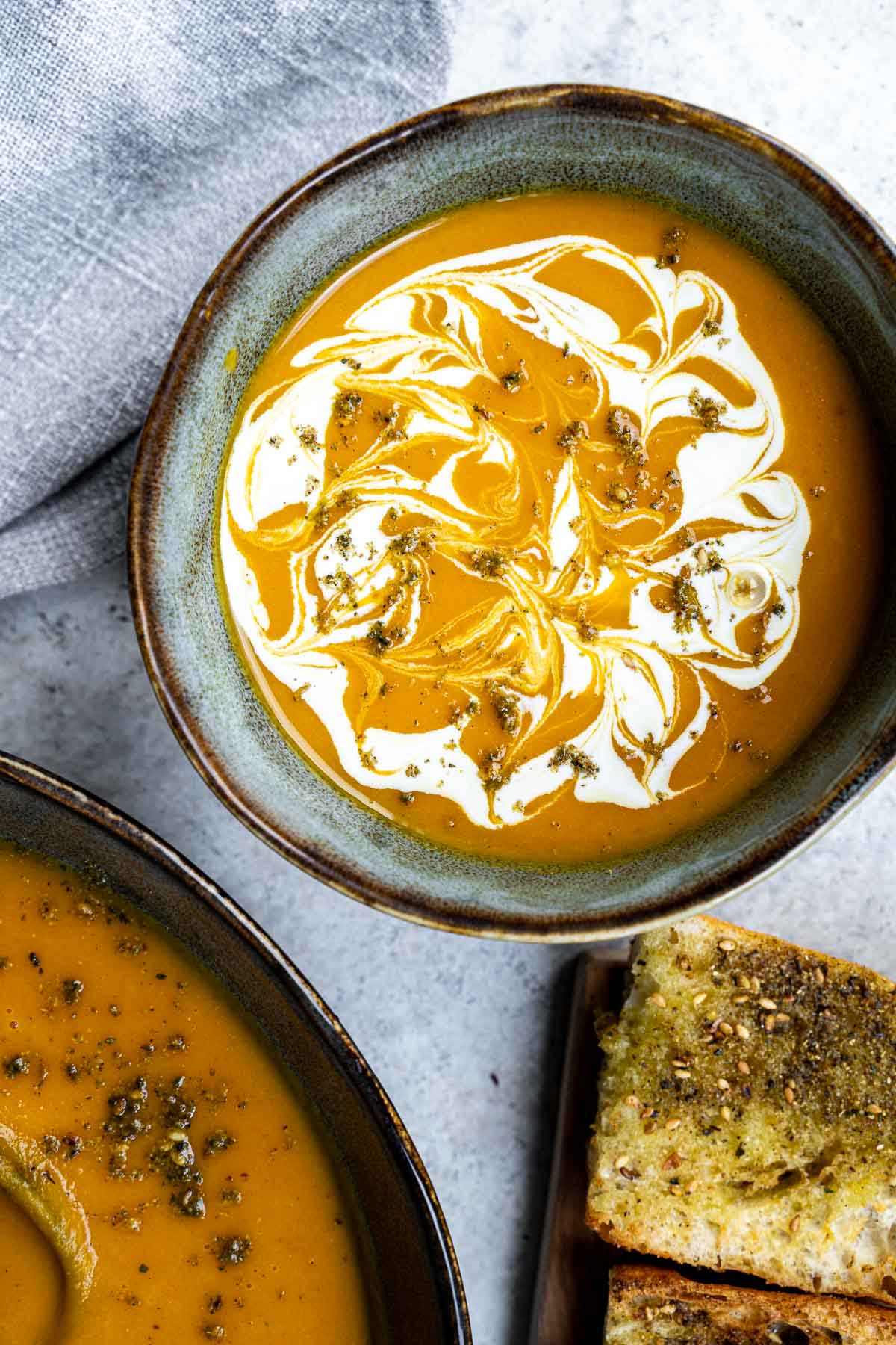 Butternut squash soup served with plant-based cream and crusty bread