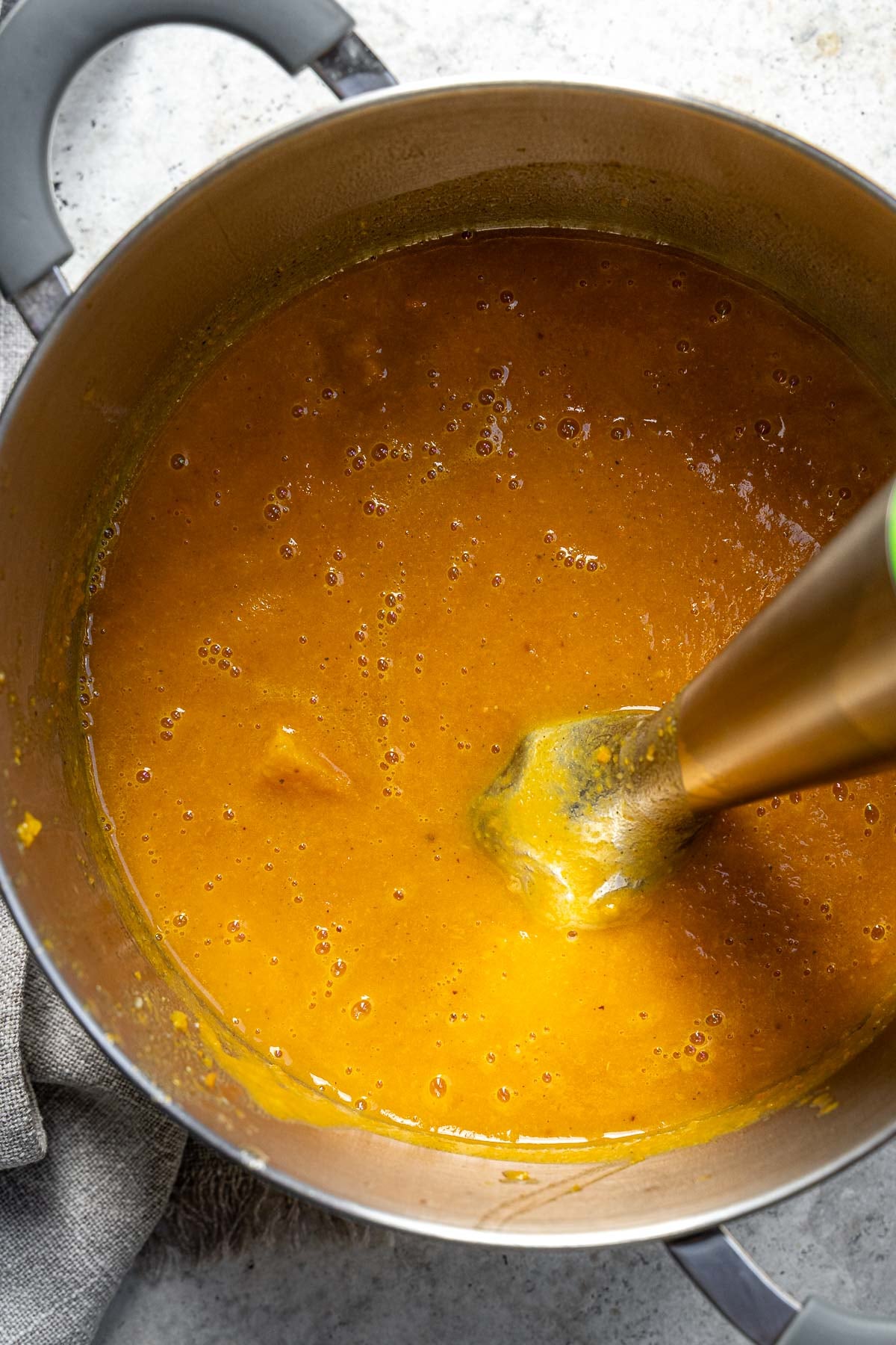 blending the soup with an immersion blender