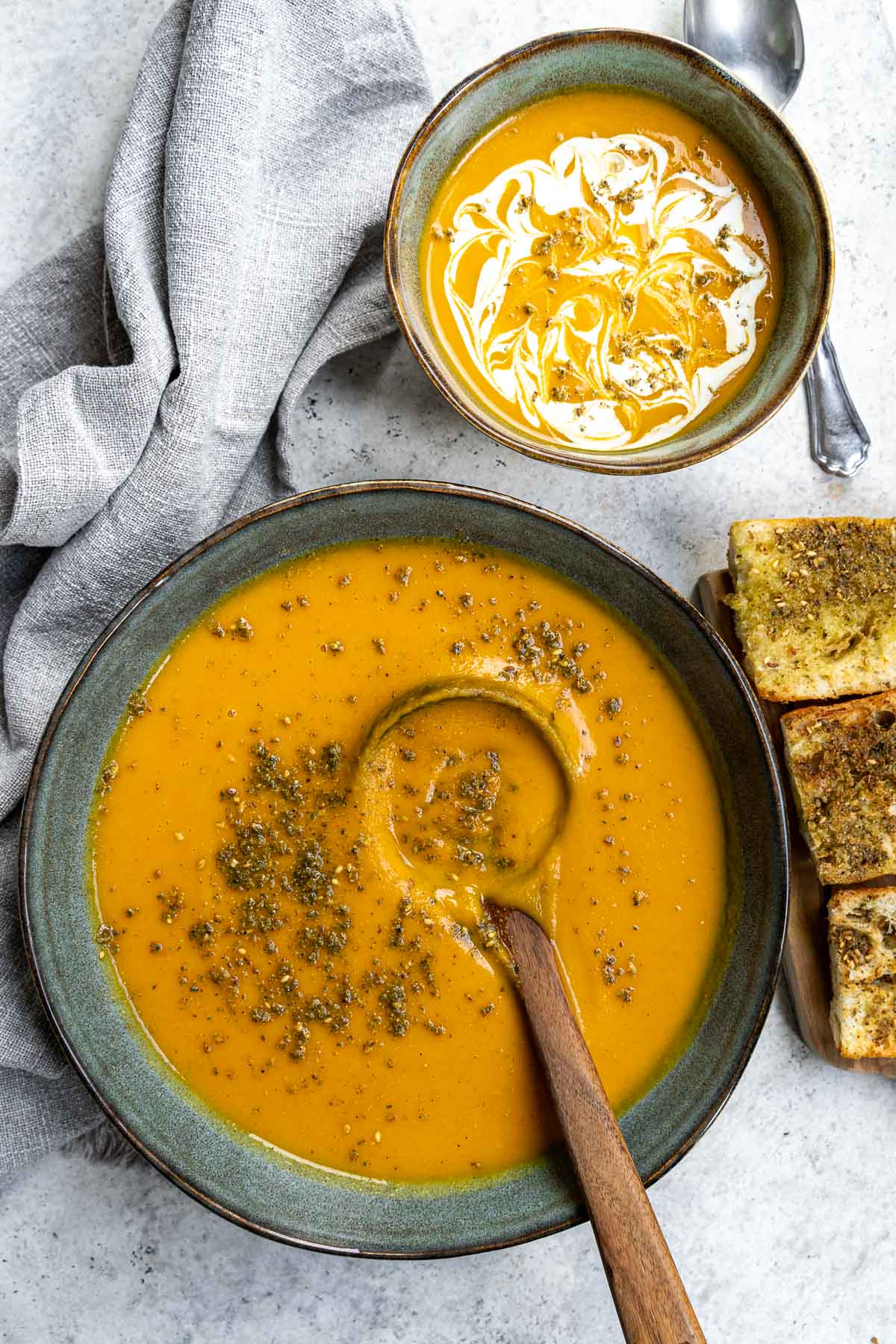 serving butternut squash and potato soup with a wooden spoon