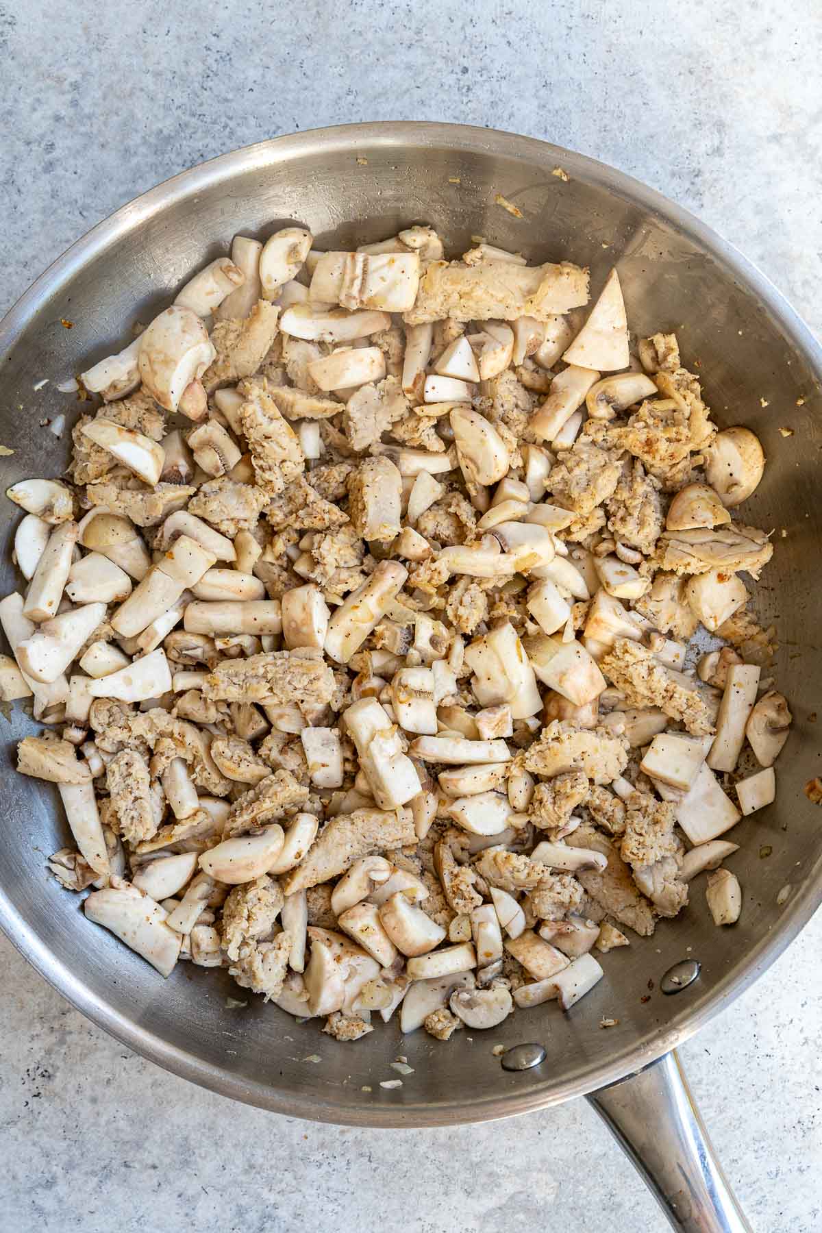 Stir frying vegan chicken pieces and mushrooms