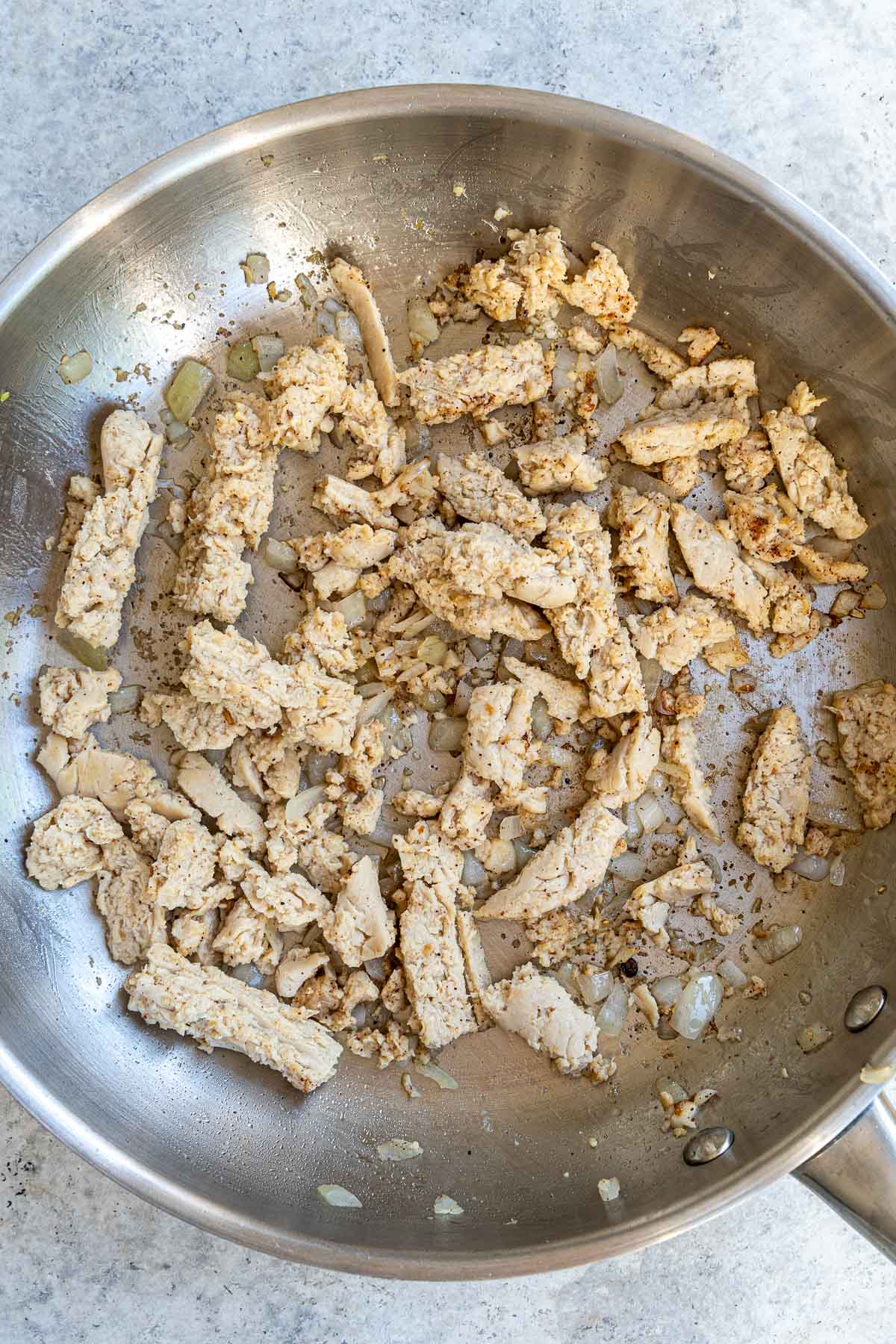 stir frying onion, garlic, and chicken pieces.